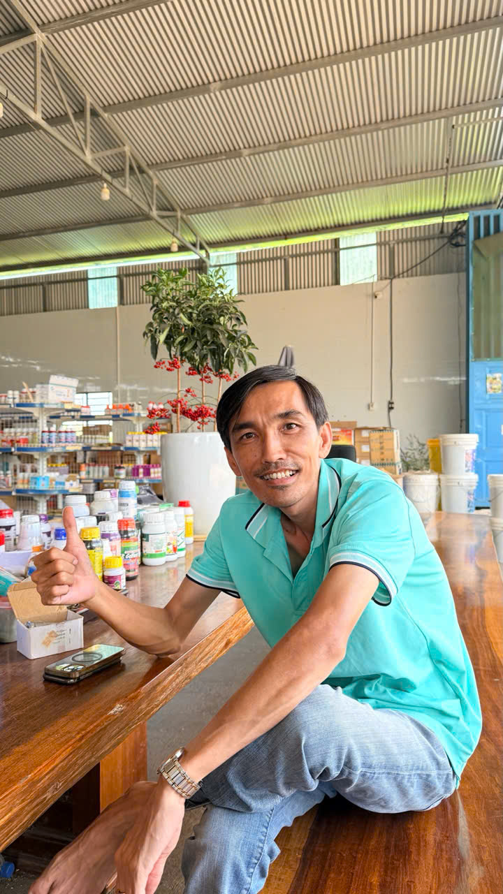 Nguyễn Quốc Dũng mỉm cười tại bàn làm việc